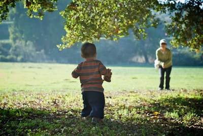 A therapist and child practicing speech outdoors in a sunny park.