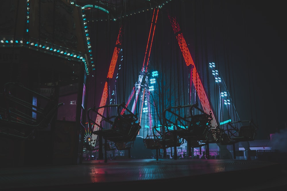 a ferris wheel lit up at night in the dark