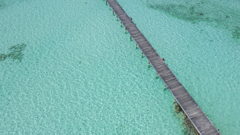 brown wooden dock on blue water during daytime