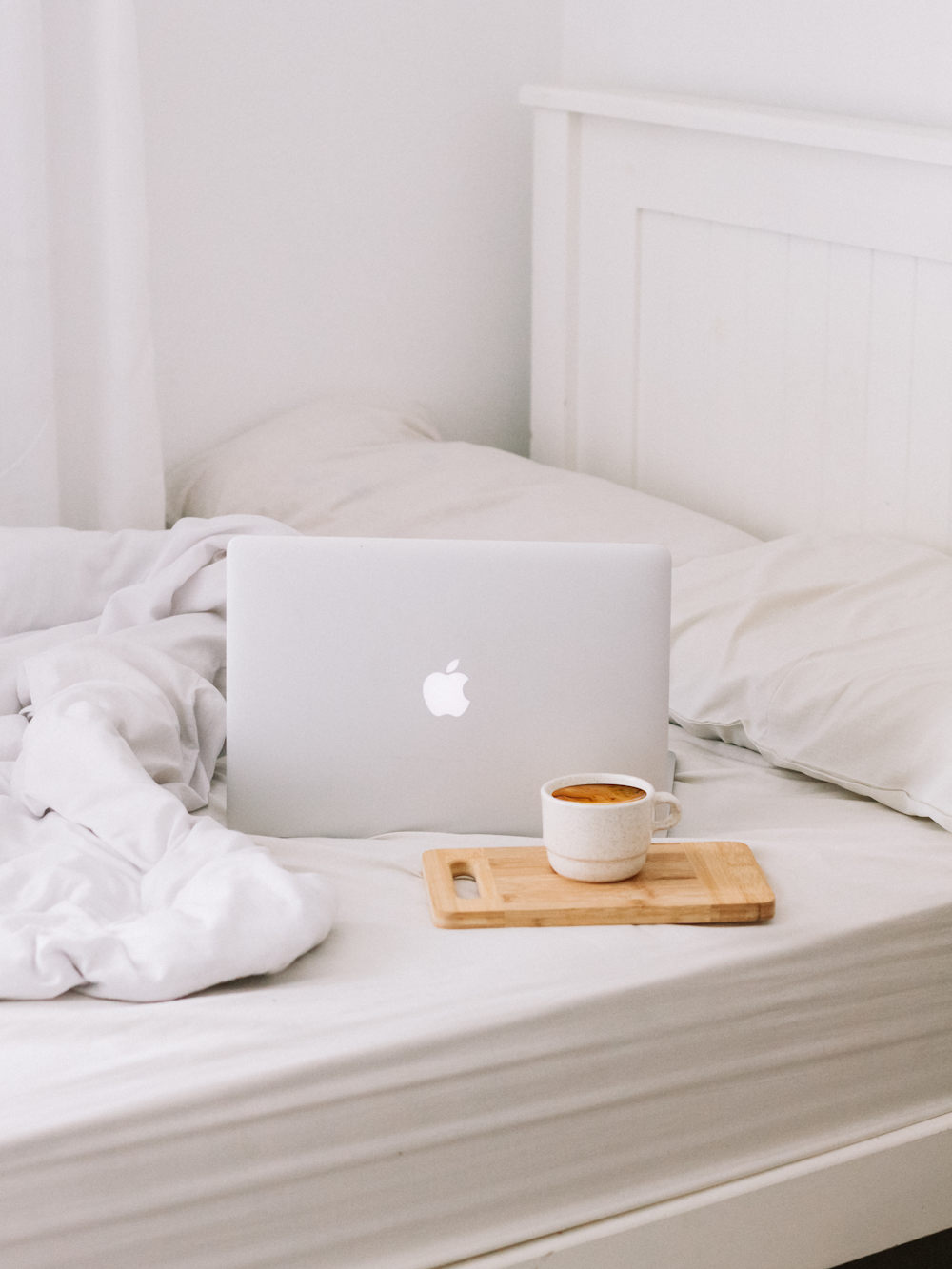MacBook neben Teetasse mit Milchkaffee