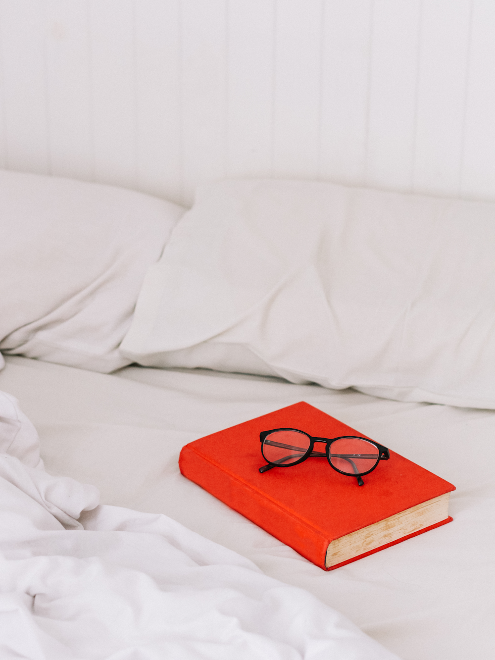 black framed eyeglasses on orange book