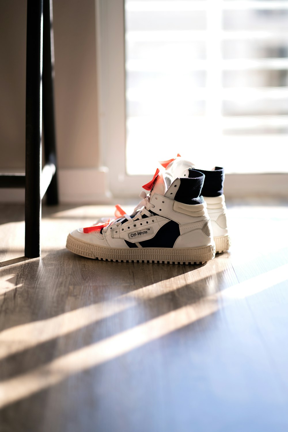 pair of white-and-black high top sneakers on floor