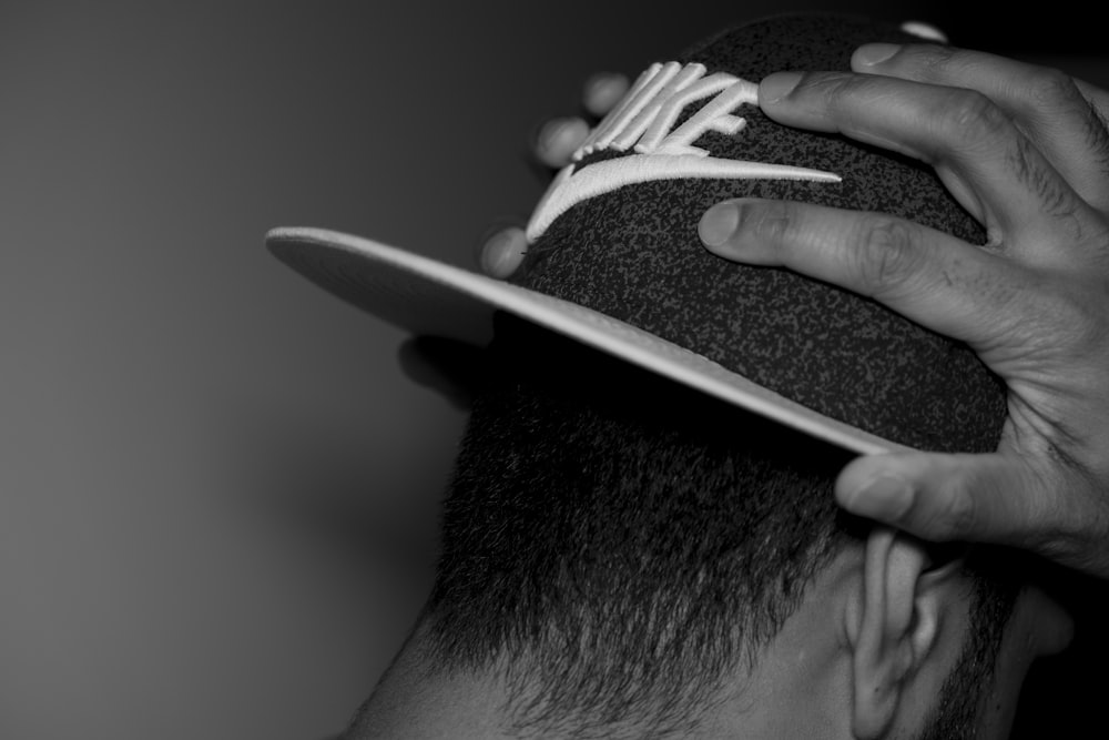 grayscale photography of man wearing cap