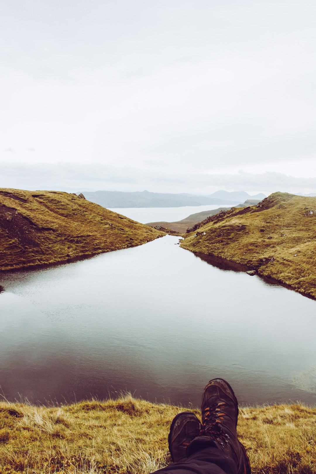 person sitting facing body of water