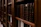 Close-up of a middle-aged man browsing books on a vintage wooden shelf at home.