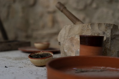 A rustic clay pot placed on a wooden kitchen table.