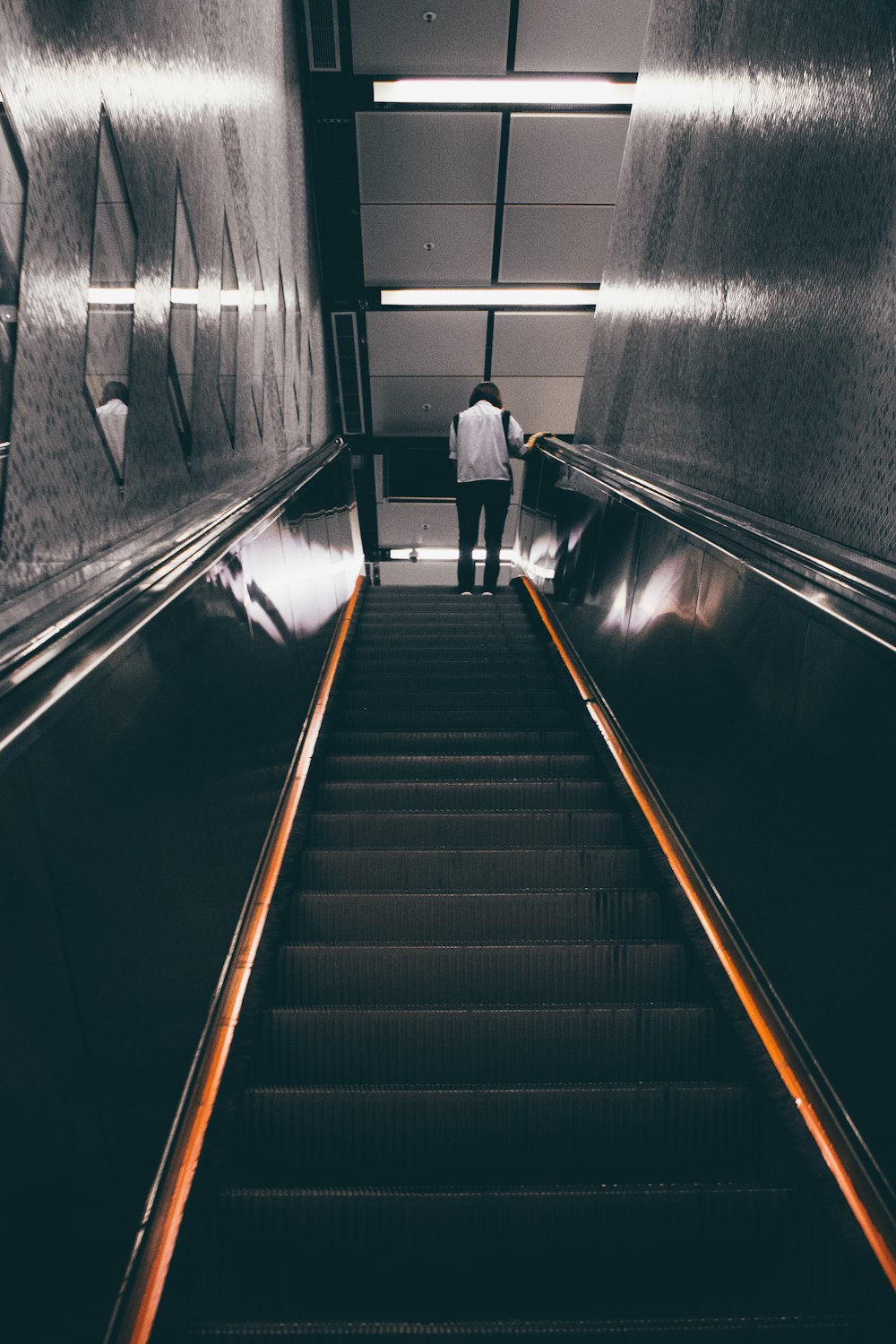 person standing on escalator