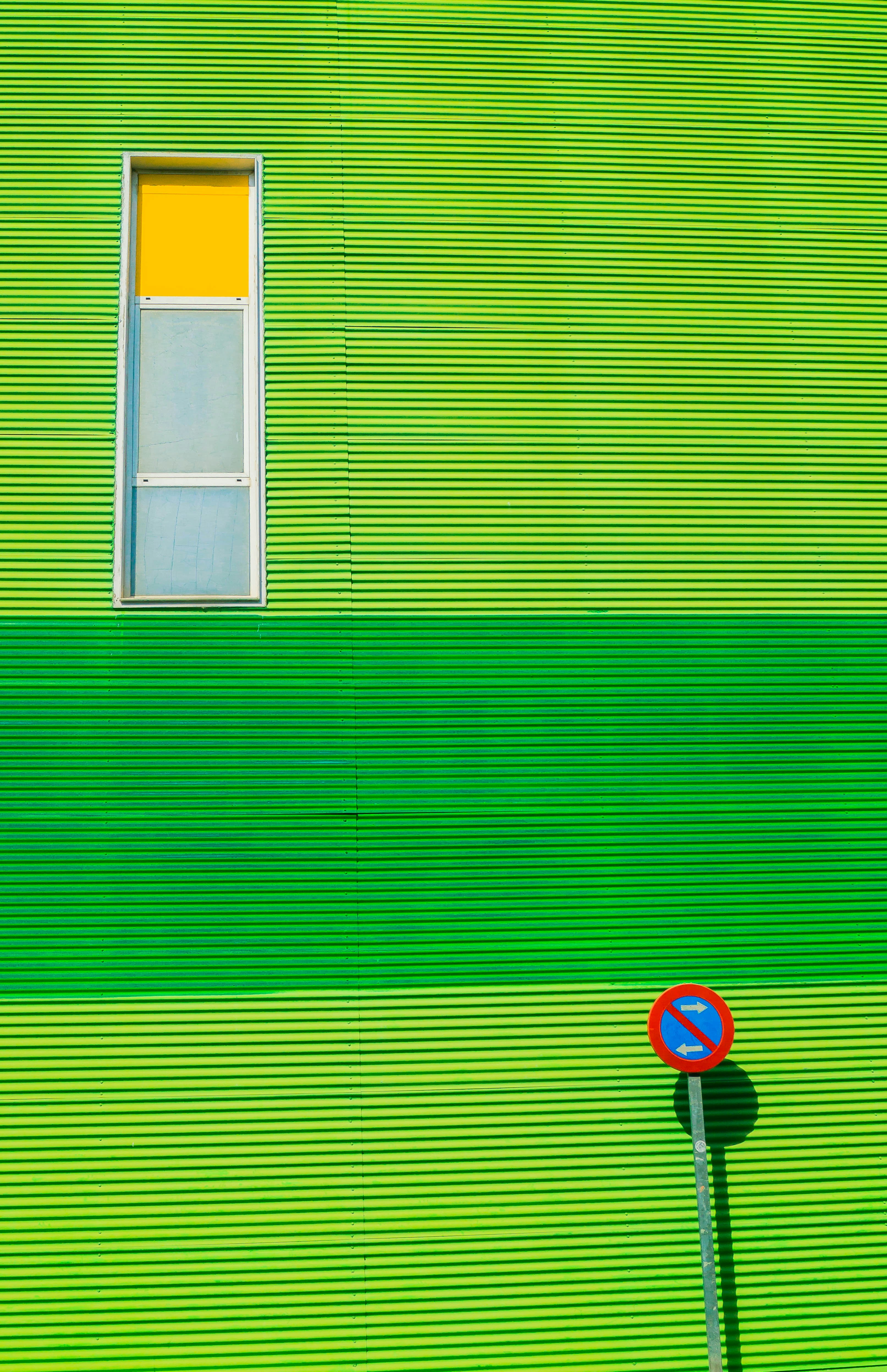 green house with road sign