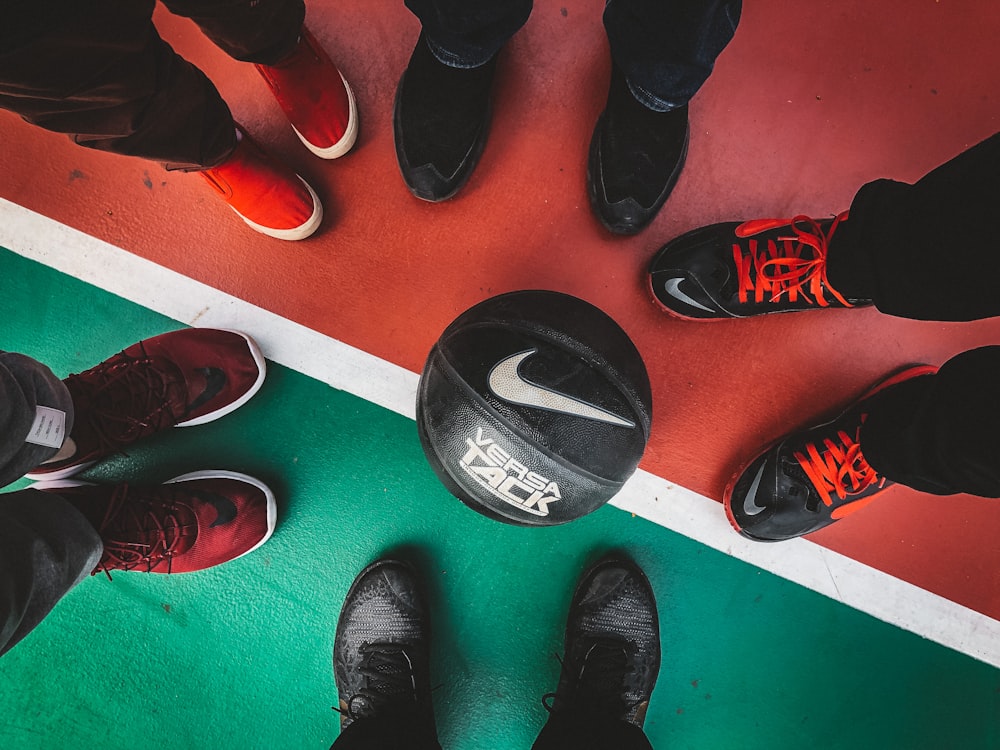 cinco personas de pie frente a una pelota de baloncesto Nike en blanco y negro
