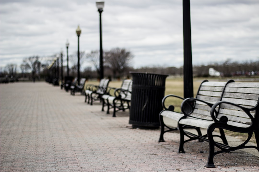 empty grey bench under grey clouds