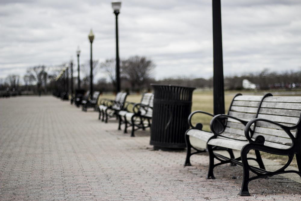 empty grey bench under grey clouds