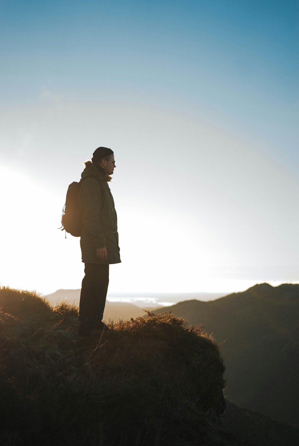 man standing on rock formation during daytime