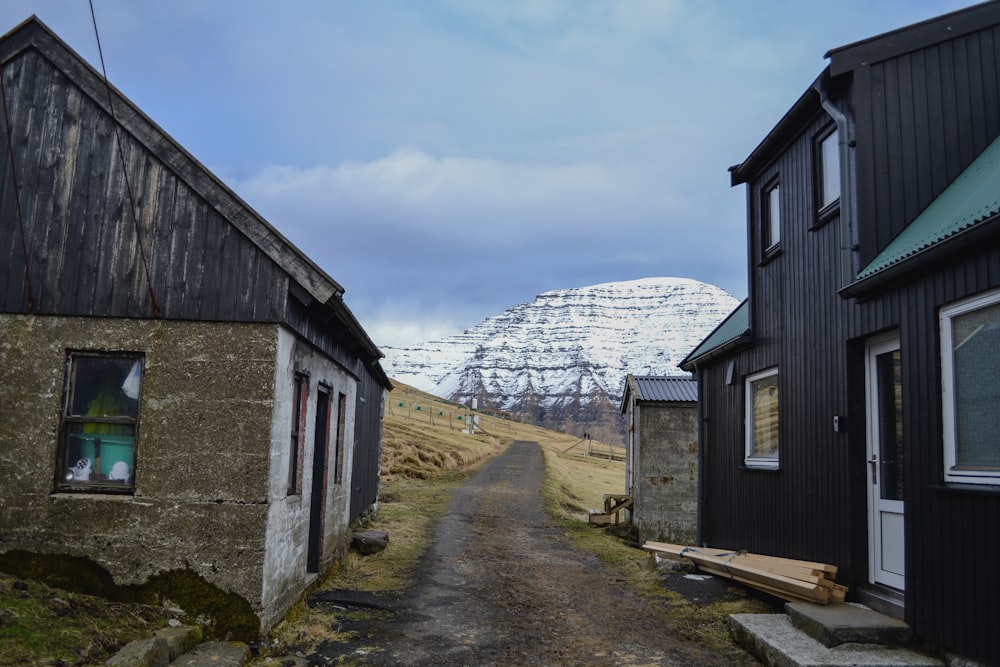 black and white wooden house near mountain under white clouds during daytime