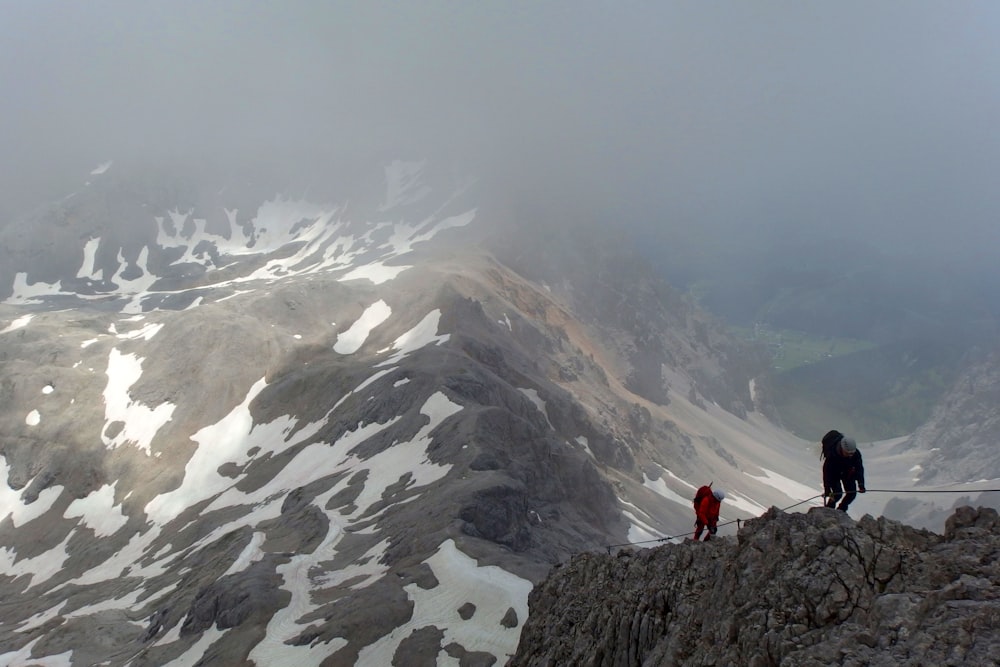 two person hiking on gray mountain