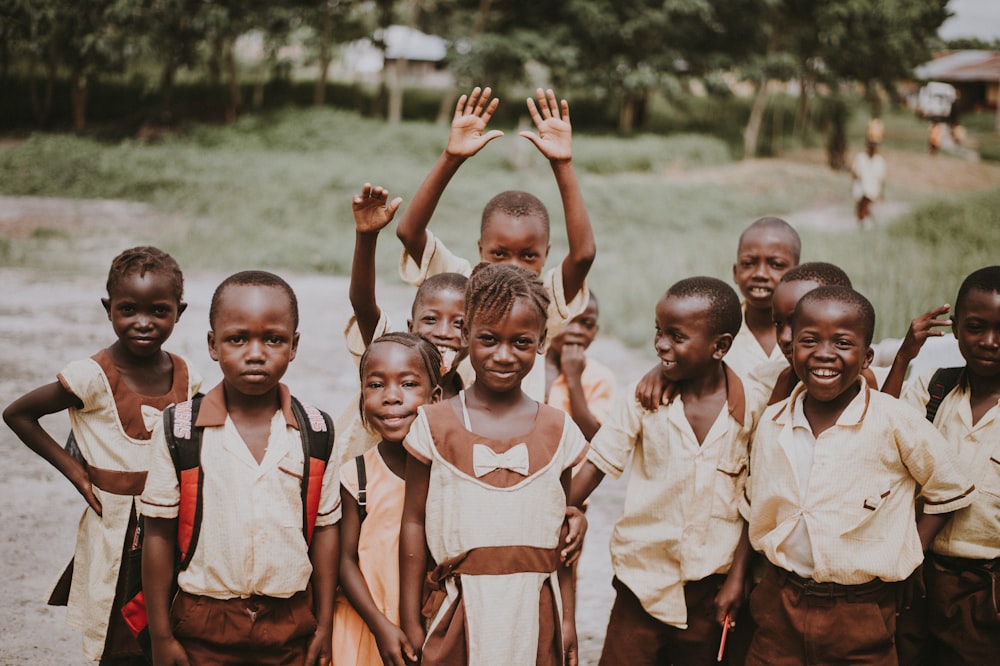 group of children standing in green field