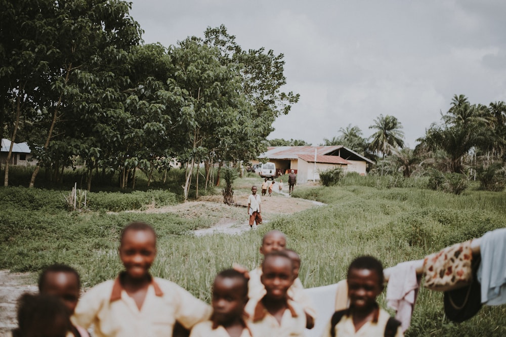 children standing near green trees during daytime