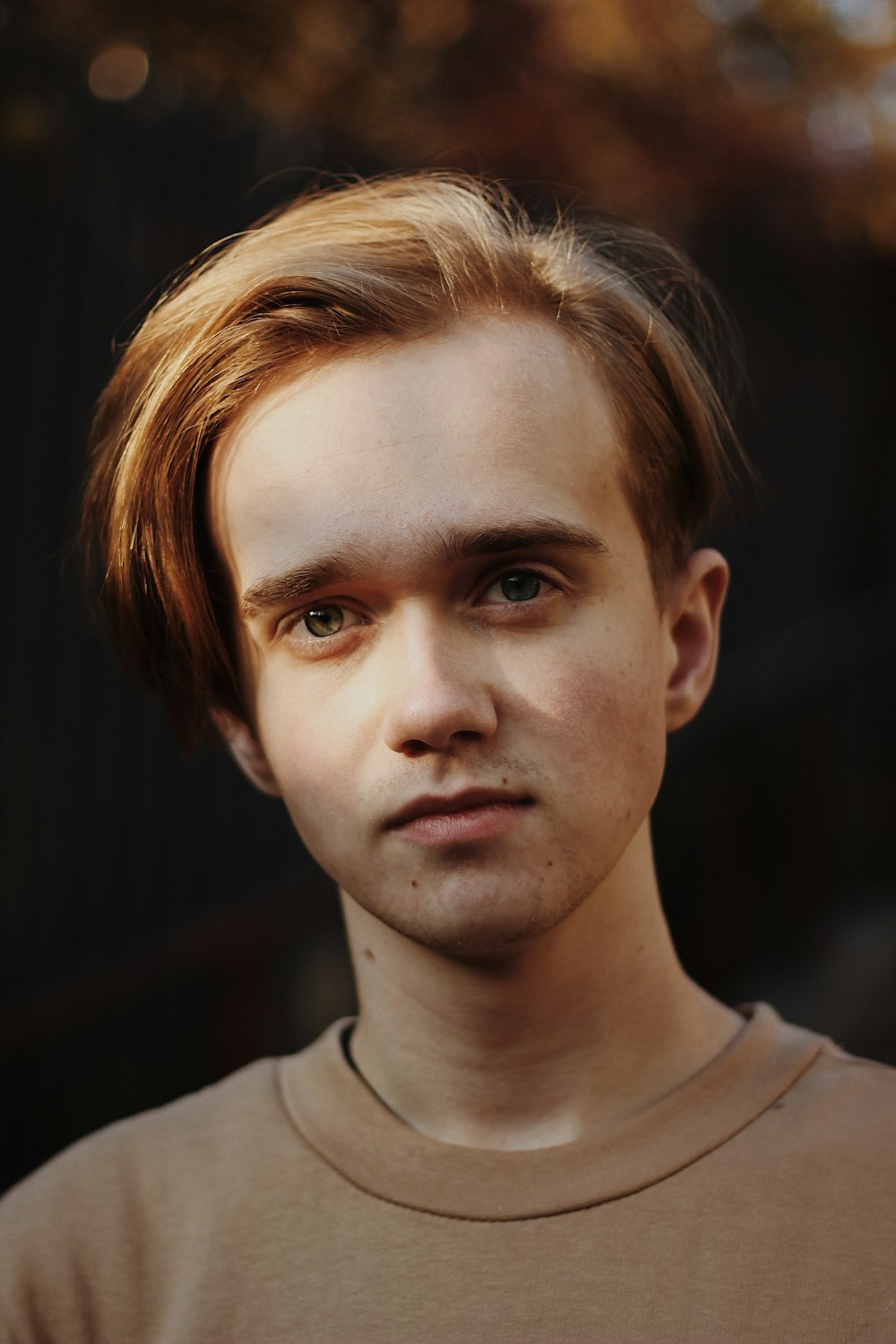 portrait photography of man wearing brown crew-neck shirt