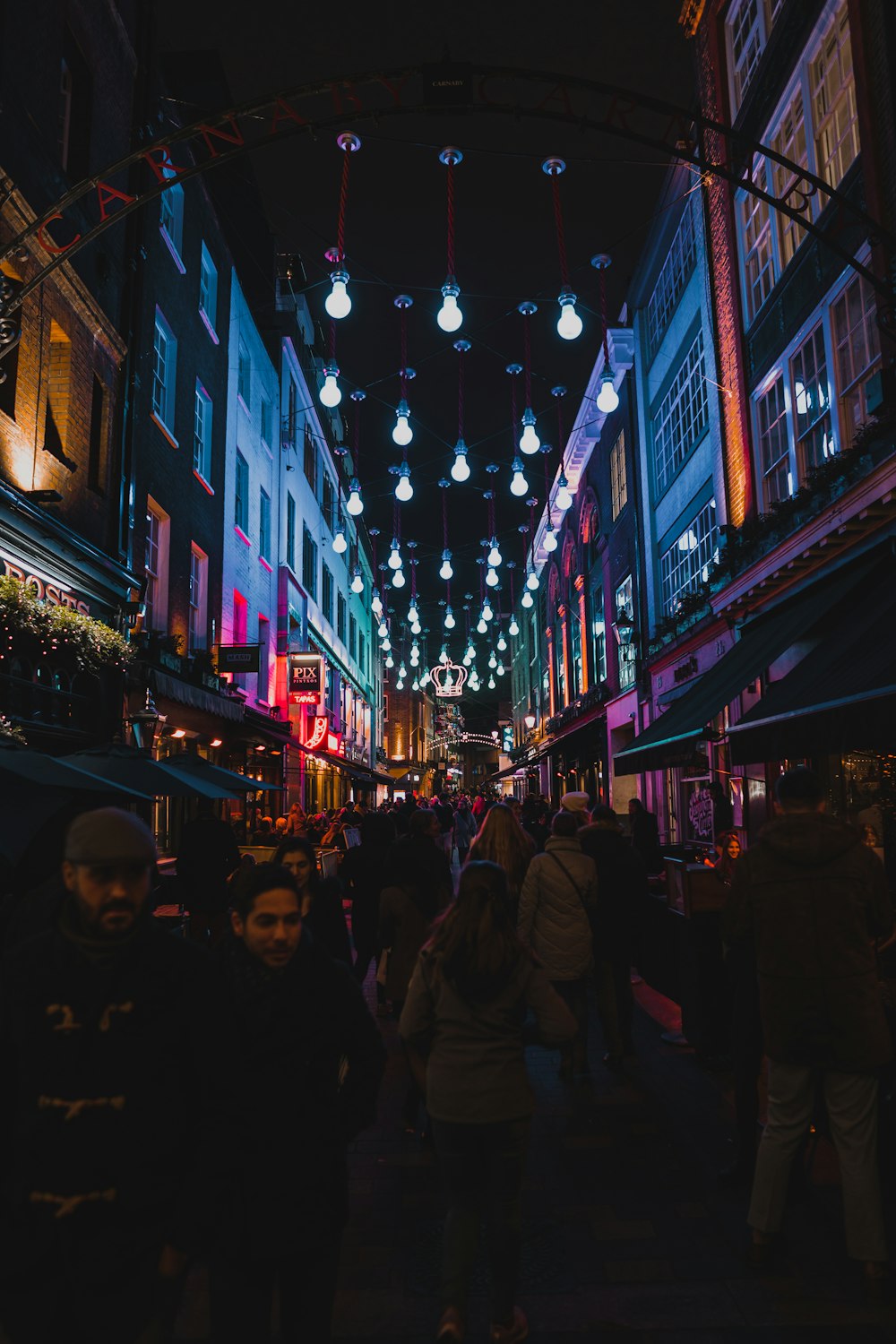 people waking between buildings during night