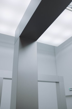 Modern minimalist office space with sleek architectural models and silver accents under soft lighting.