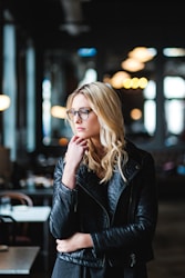 woman resting her head on her hands while looking sideways inside well lit room