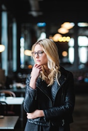 woman resting her head on her hands while looking sideways inside well lit room