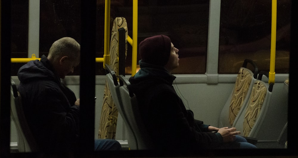 men sitting on bus seat
