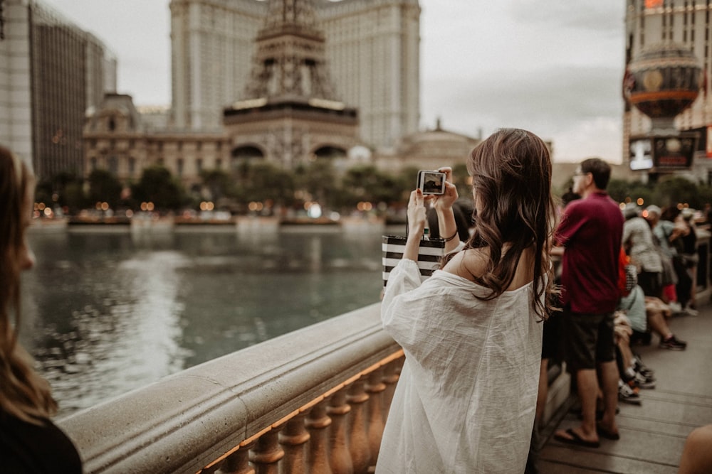 woman taking photo of view of water