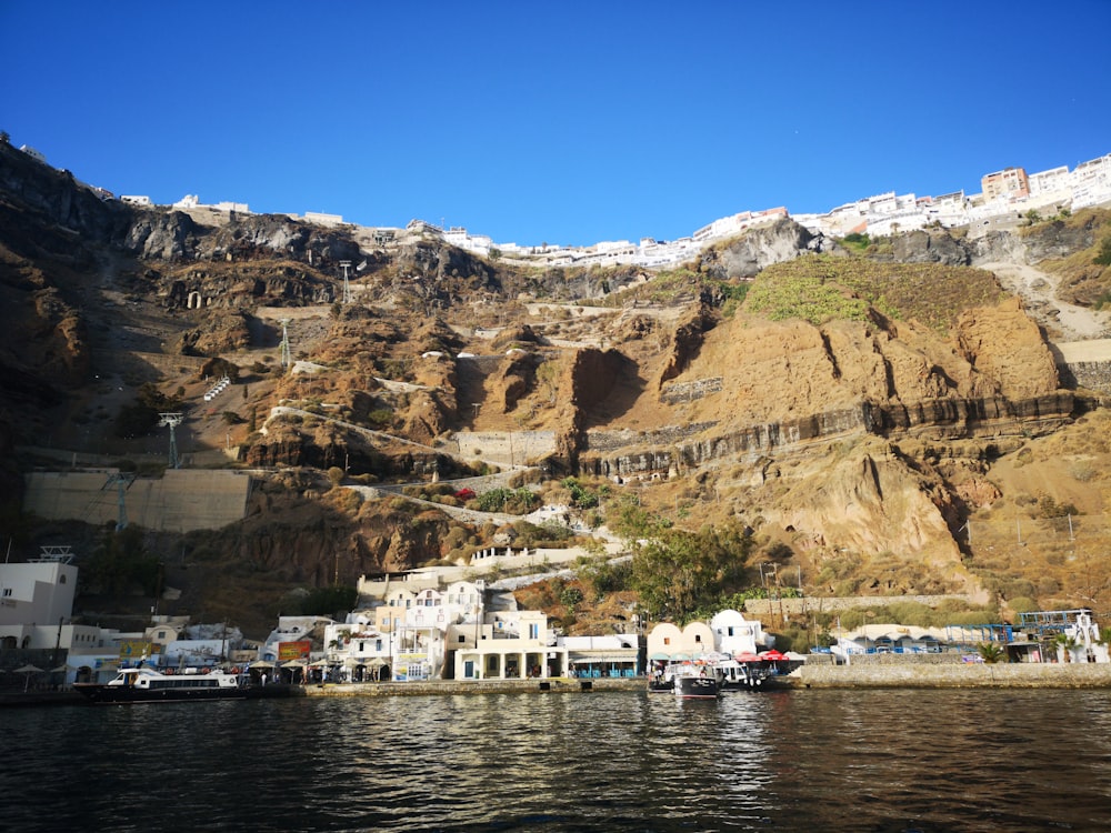 houses over brown rock formation under blue sky