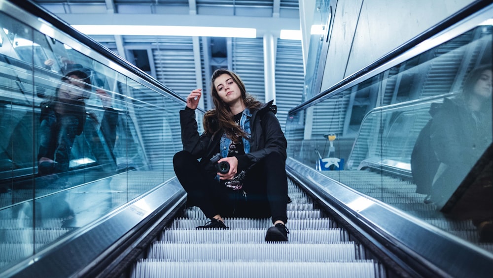 woman sitting on escalator