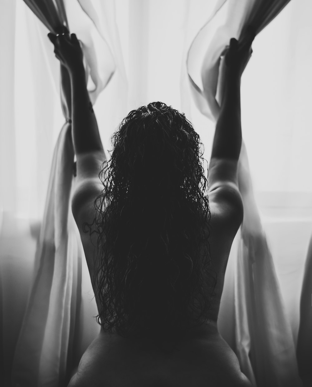 naked woman clinging on curtain