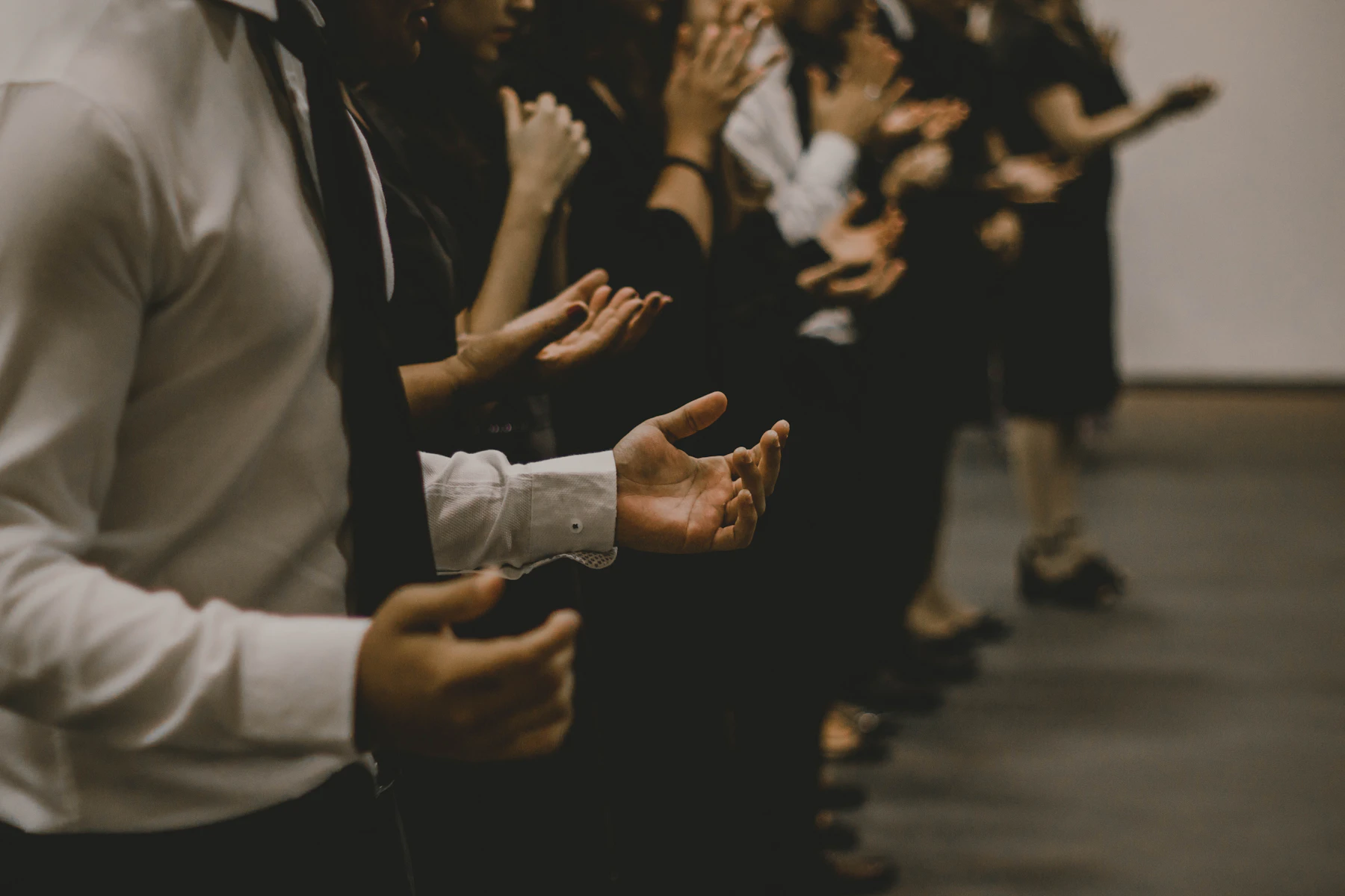People praying together with hands raised