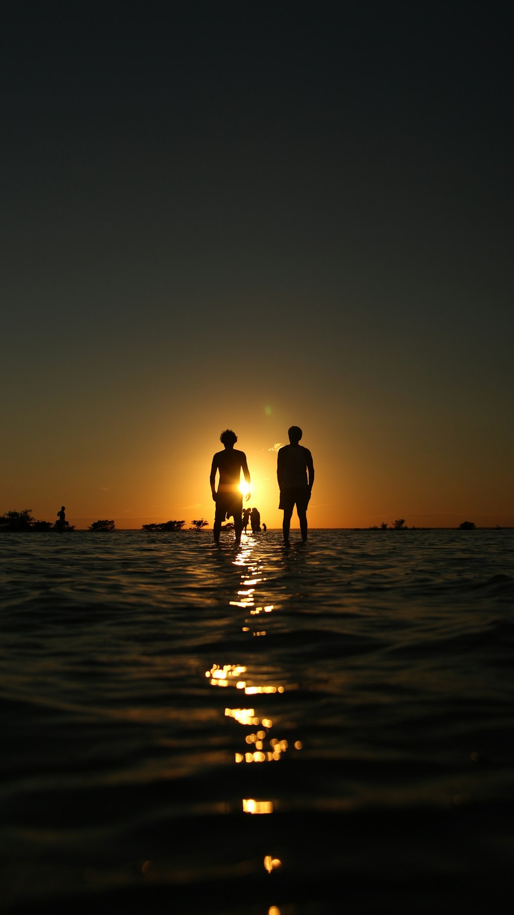 two people standing in ocean