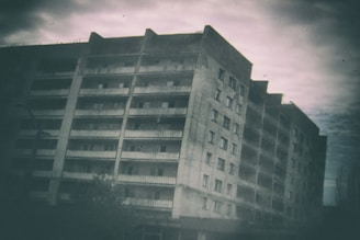A player scavenging loot from a derelict building under a cloudy sky.