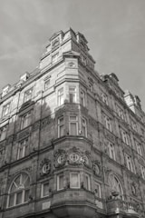 A historic stone building featuring intricate architectural details such as decorative moldings and symmetrical window arrangements. The structure appears tall and imposing, with its facade offering a vintage aesthetic.