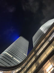 Sleek modern residential towers illuminated at dusk, showcasing luxury architecture.