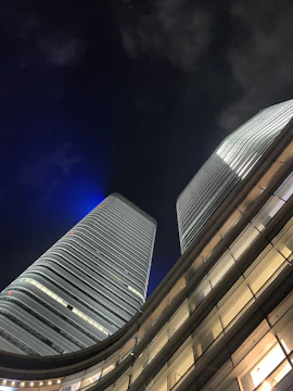 Sleek modern residential towers illuminated at dusk, showcasing luxury architecture.