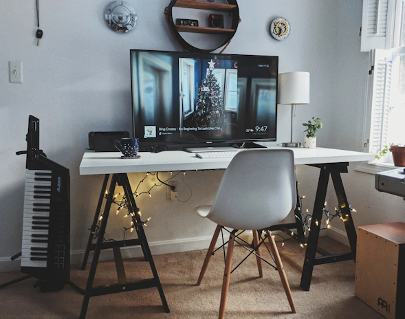 A cozy workspace with a laptop open to social media pages showing song lyrics and quotes.