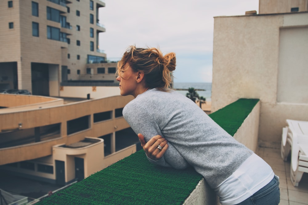 man leaning forward on ledge during day