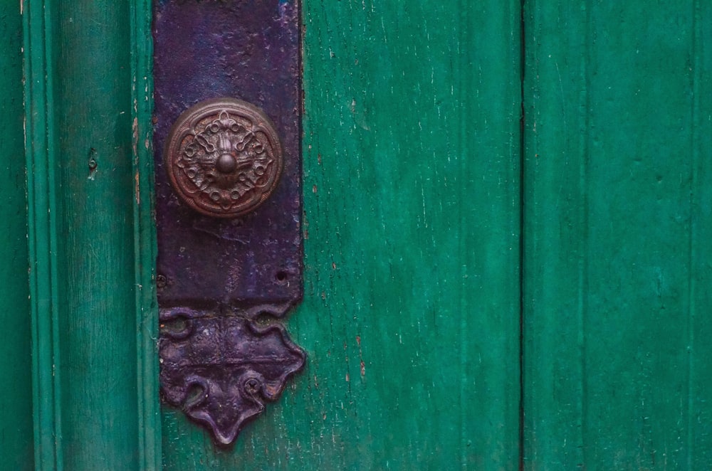 green wooden door with brass door knob