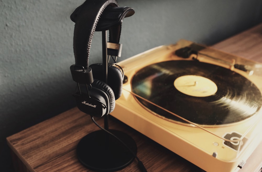 black and beige turn table beside black headphones