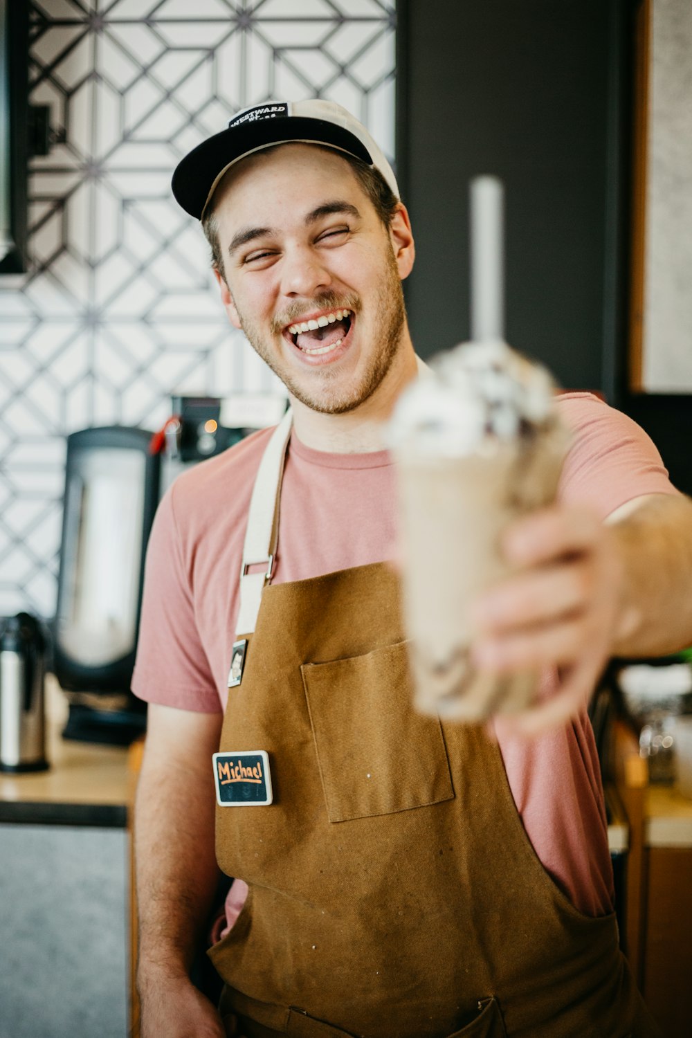 hombre riendo mientras sostiene una taza de helado