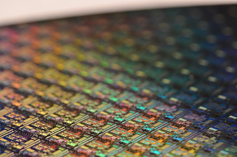 Close-up of a semiconductor wafer showing iridescent chip patterns