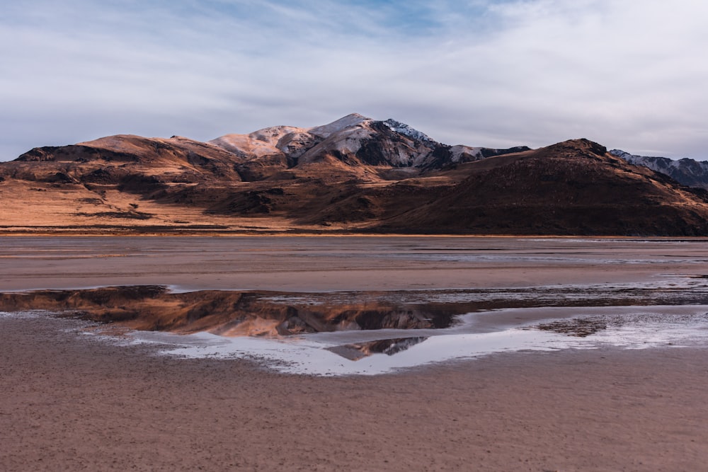 Montaña marrón con reflejo en el agua