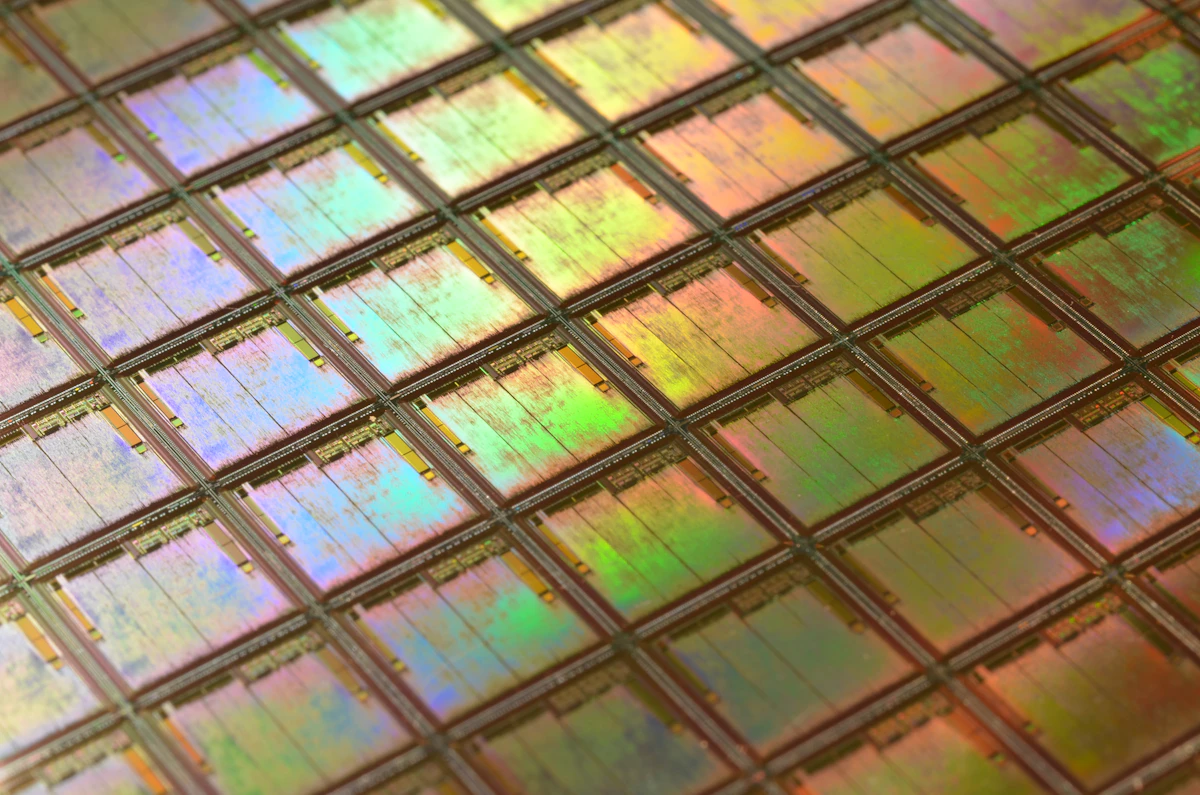 Macro photograph of iridescent chip dies on a silicon wafer.