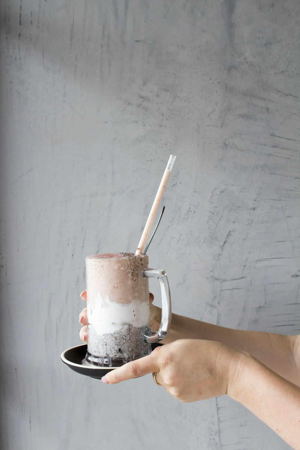 person holding glass of milkshake