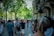 A diverse group of tourists exploring a vibrant city street filled with culture and life.