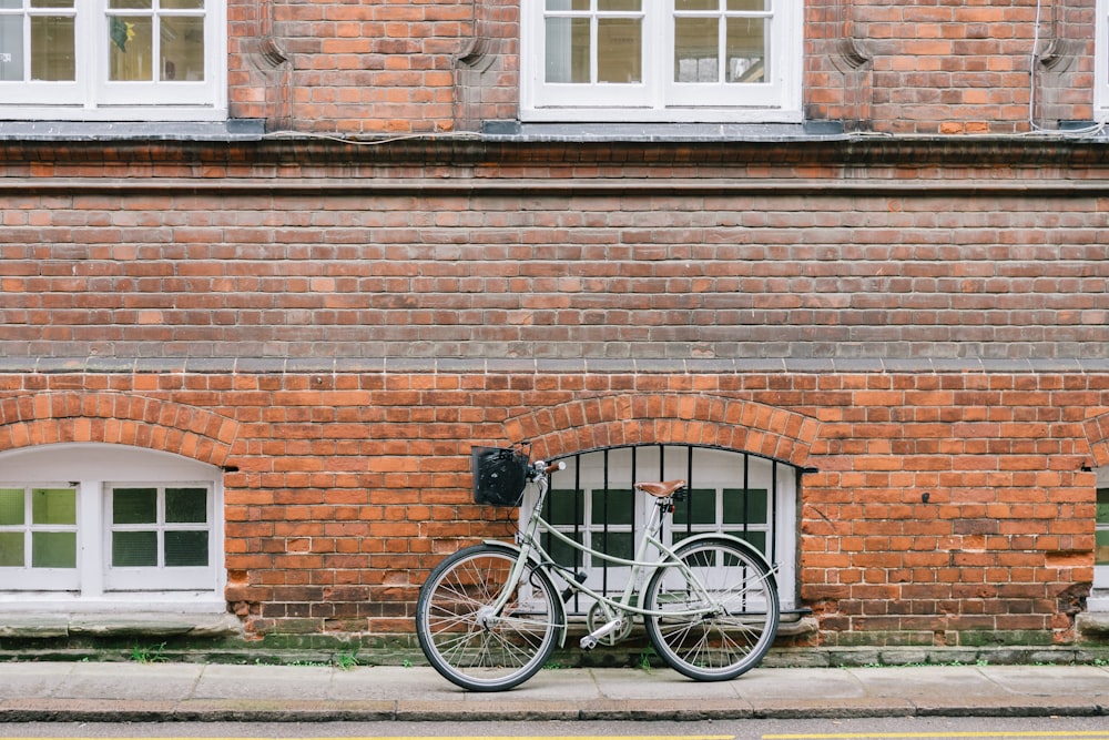 bicycle parked beside brown wall