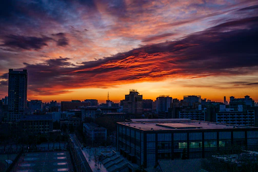 A vibrant drone shot capturing a sunset over a bustling cityscape.