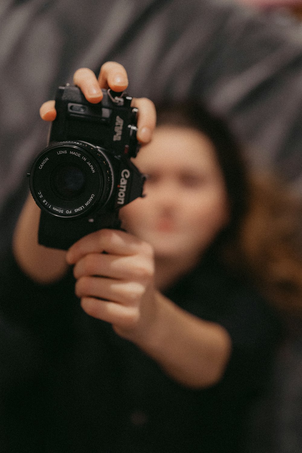 femme tenant un appareil photo argentique Canon