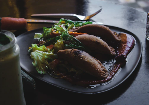 A vibrant platter of golden milanesas with colorful sauces and fresh sides on an industrial-style table.